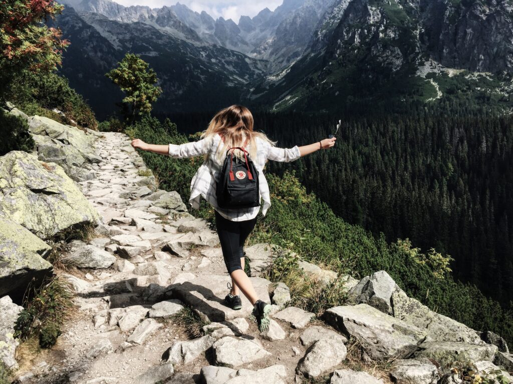 woman hiking on trail in mountains
