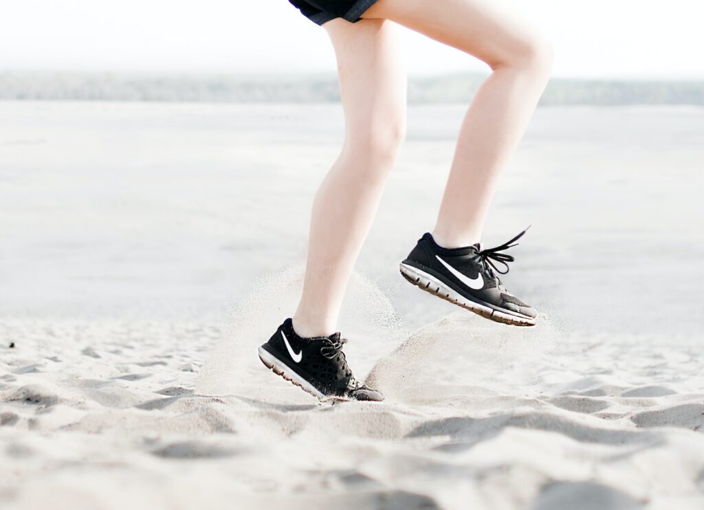 person running on beach exercising to boost energy 