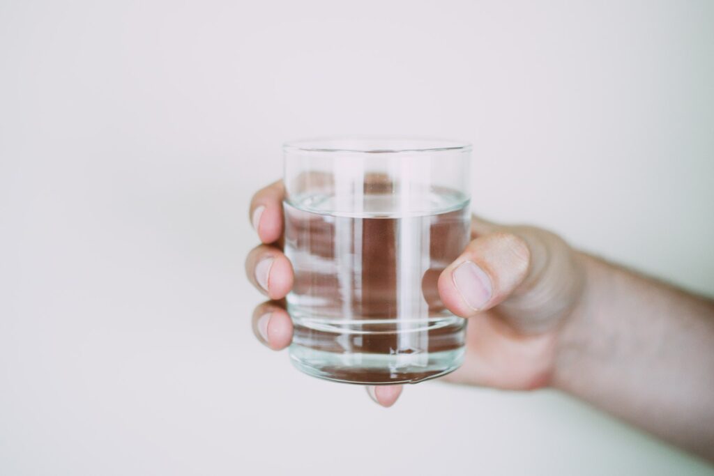 Person Holding Drinking Glass of water to boost energy