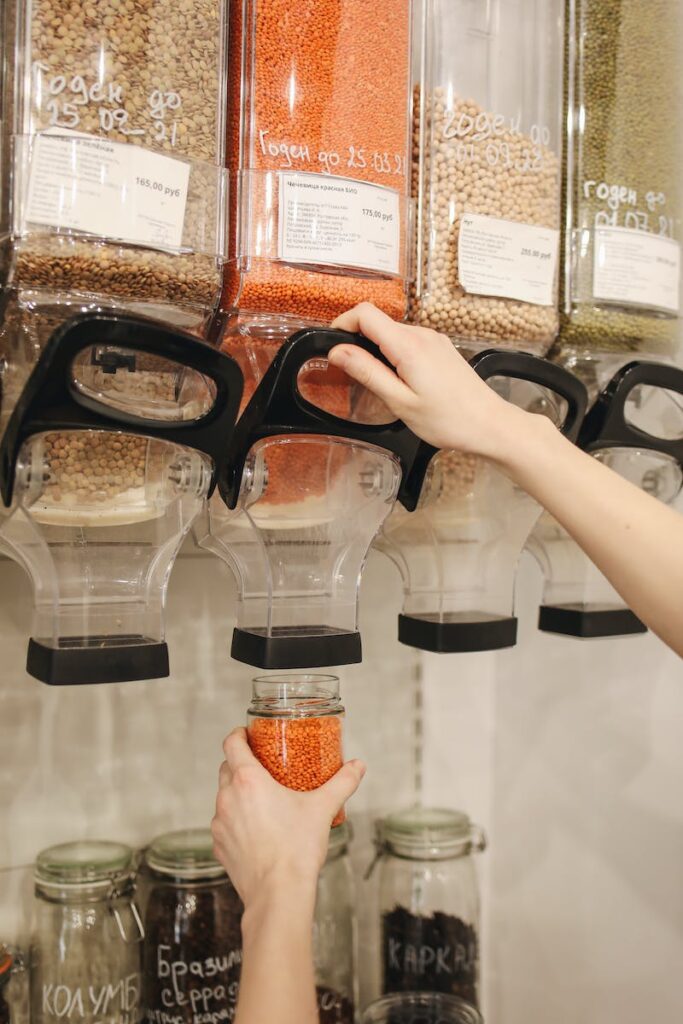 person showing Zero Waste lifestyle by reusing glass jars to shop for goods.