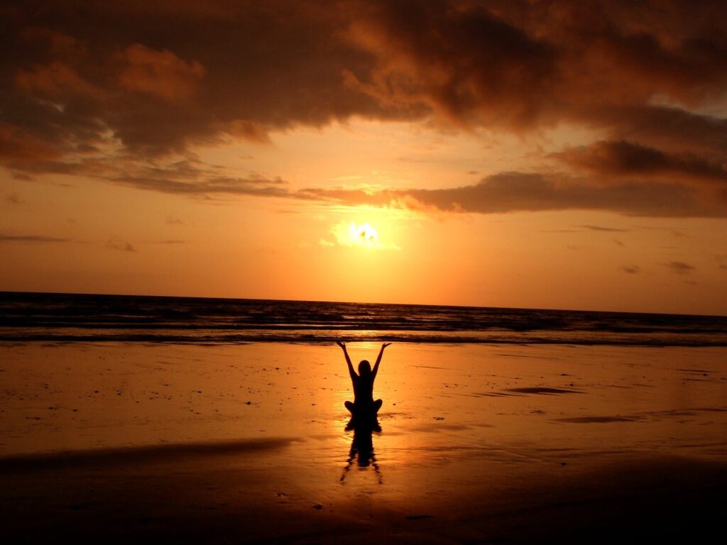 Silhouette of Person raising hands meditating and manifesting with positive affirmations