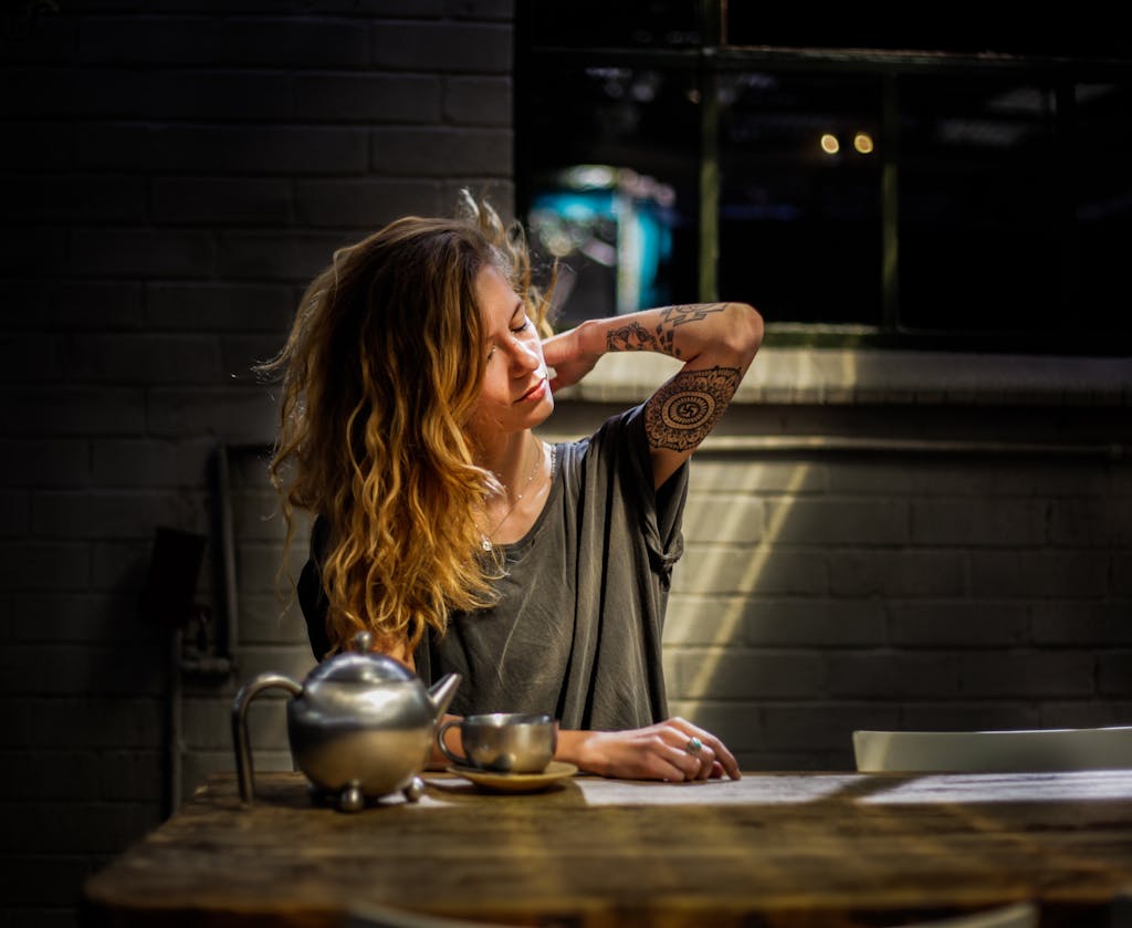 Woman Sitting Beside Table stressed who needs to work on self care 