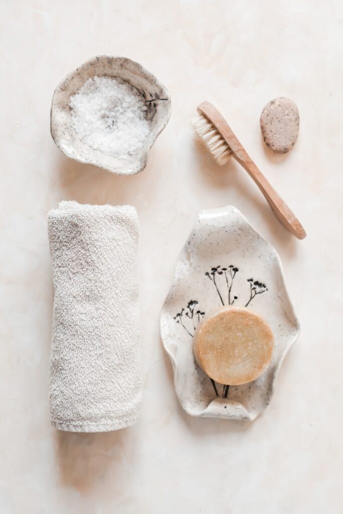 Zero waste and clean ingredient products showing bamboo brush, shampoo bar, salt, stone & washable rag. 