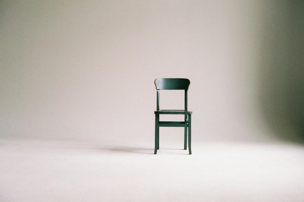 A single black chair in a minimalistic setting.