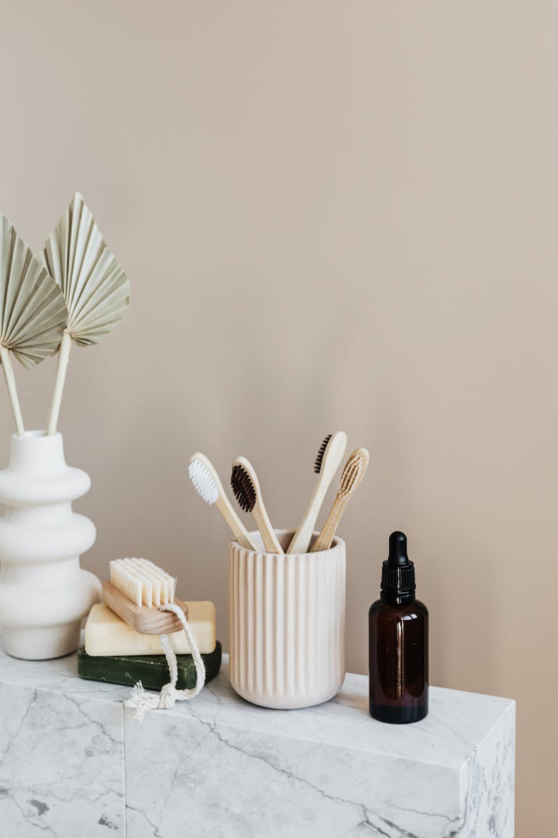Collection of eco friendly bamboo toothbrushes and organic natural soaps with wooden body brush arranged with recyclable glass bottle with natural oil